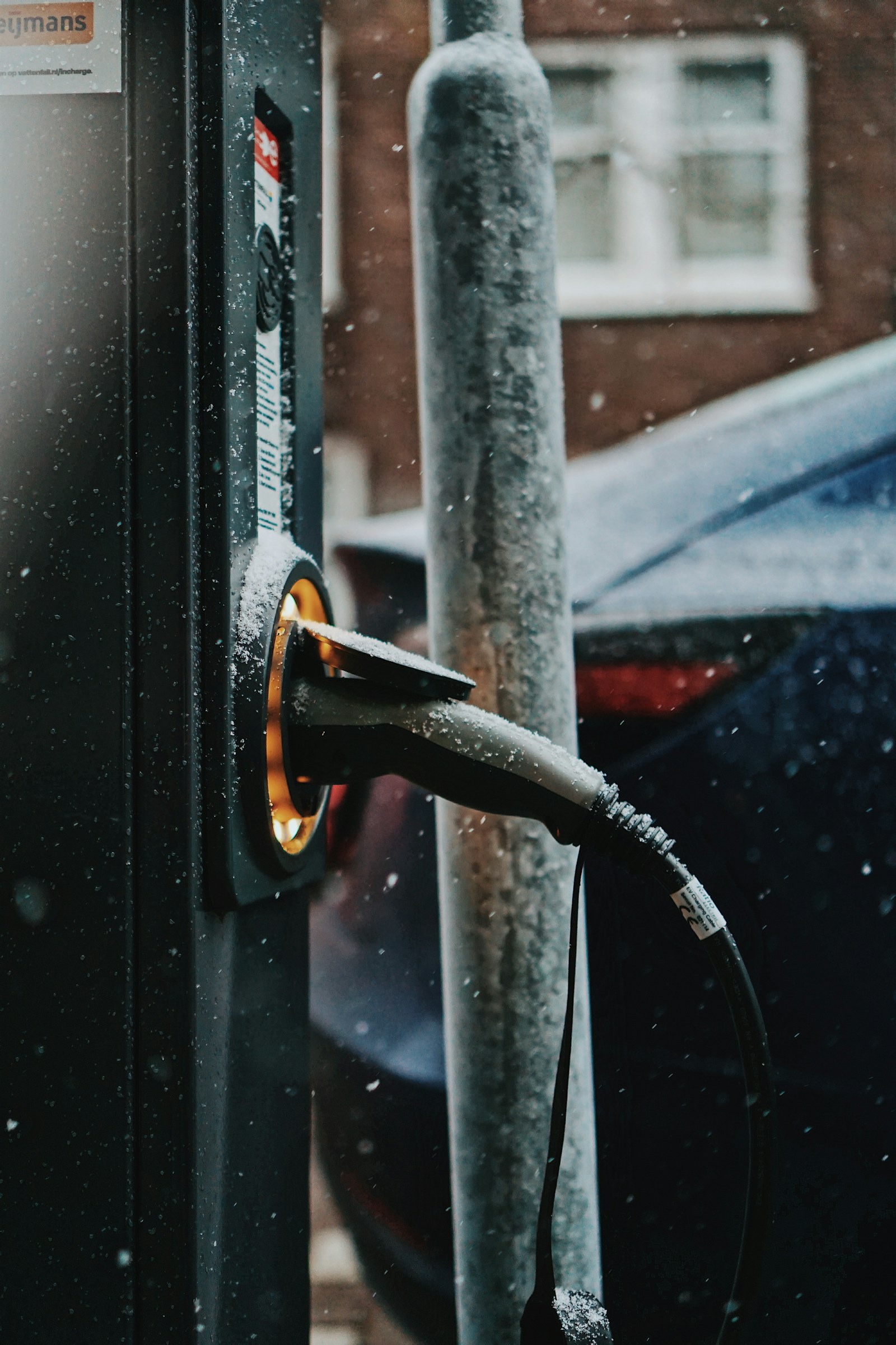 A charging cable connected to a black car